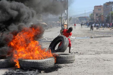 A demonstrator moves a tyre to a burning barricade during a protest for the recent killings of police officers by armed gangs, in Port-au-Prince, Haiti January 26, 2023. REUTERS/Ralph Tedy Erol/File Photo