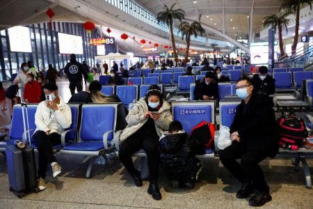 People wait with their luggages at a railway station, amid the coronavirus disease (COVID-19) outbreak, in Wuhan, Hubei province, China January 1, 2023. REUTERS/Tingshu Wang