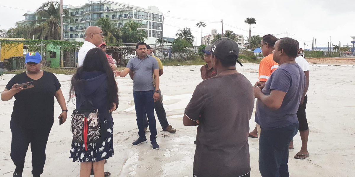Minister of Public Works Juan Edghill and Minister within the Ministry of Public Works Deodat Indar speaking with truck drivers at the empty parking lot at Red Road, Providence, East Bank Demerara, yesterday