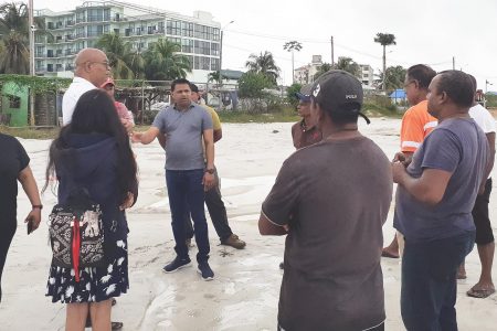 Minister of Public Works Juan Edghill and Minister within the Ministry of Public Works Deodat Indar speaking with truck drivers at the empty parking lot at Red Road, Providence, East Bank Demerara, yesterday
