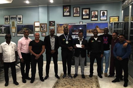 Nazar Mohamed, Proprietor of Mohamed’s Enterprise, presenting the sponsorship cheque to
Carl Ramsay in the presence of several members of the GMMAF executive committee