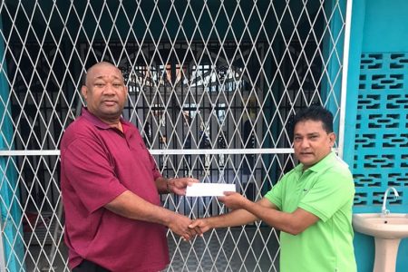 Ramdial Ramoutar (right) of Double R hands over his contribution to BCB President Hilbert Foster.