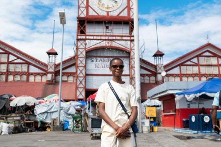 Guyanese-born British actress Letitia Wright, who played the major role of Shuri in the Black Panther movies poses in front of the famous Stabroek Market.  Wright arrived in Guyana on Friday night and has been touring the land of her birth. (Ministry of Tourism, Industry and Commerce photo)