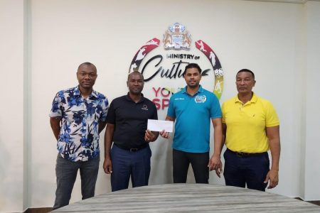  Minister of Culture, Youth and Sport Charles Ramson Jr., (2nd from right) presents the cheque of approximately GYD$32.3M representing prize money and player stipend for the maiden edition of the One Guyana President’s Cup Football Championship which concluded on January 1st to GFF President Wayne Forde. Also in the photo are GFF Vice-President Deon Inniss (left) and NSC Chairman and Kashif and Shanghai Co-Director Kashif Muhammad, right.
