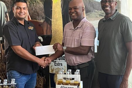 From left, Top Brandz Marketing Manager Dinesh Ramsahai hand over check to Vice President of the LGC Brian Hackett with LGC Public Relations Officer, Paton George