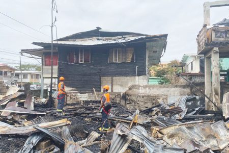 Firefighters examining the remains of the fire yesterday