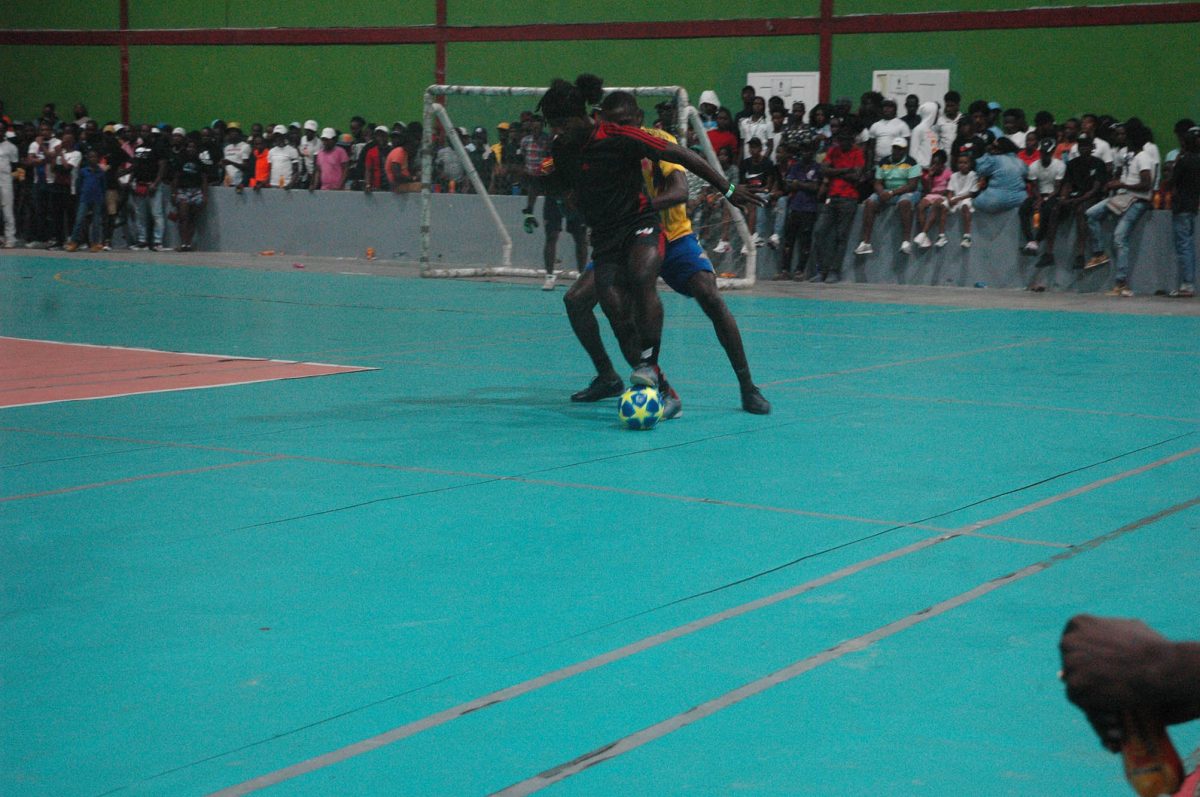 Trayon Bobb (black) of Bent Street trying to maintain possession while being challenged by Amos Ramsay of Back Circle