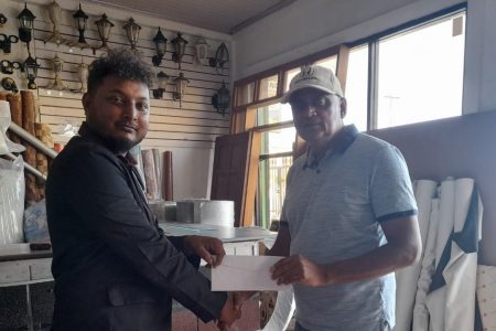 Business Development Manager at Raj Singh Insurance Brokers, Loakendra Ramdeo (left)  presenting the claim settlement cheque to Zaid Mohammed of Zaid Mohamed & Sons Trading
