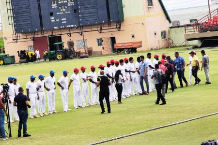 Minister of Culture, Youth and Sport Charles Ramson Jnr., greets the Demerara and Berbice cricketers before the start of play yesterday. He was accompanied by former West Indies skipper Ramnaresh Sarwan, current chairman of the national selectors, Kashif Muhammad, chairman of the National Sports Commission and Steve Ninvalle, Director of Sport. (Donald Duff photo)
