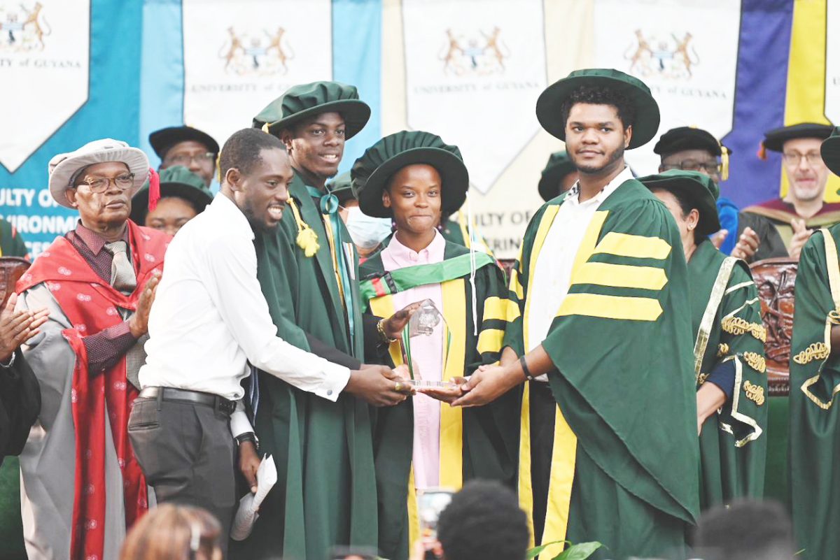Guyana-born British actress Letitia Wright (centre) being presented with a plaque by members of the University of Guyana’s Student Society (Ministry of Tourism, Industry and Commerce photo)