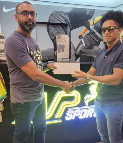 Chief Executive Officer of MVP Sports, Ian Ramdeo (left) hands over the sponsorship agreement to boxer Keevin Allicock.