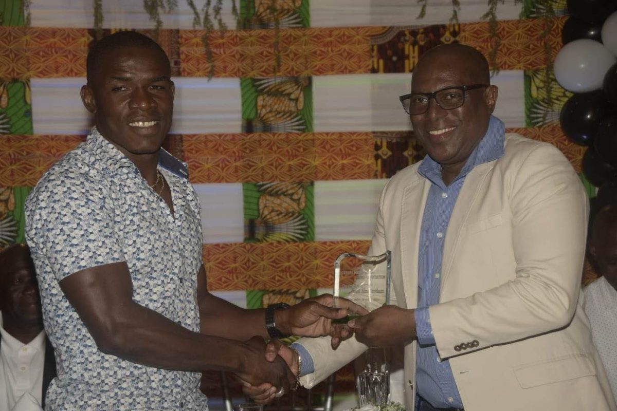 ALL SMILES! Boxer Desmond Amsterdam   smiles as he receives his Boxer-of-the-Year award from president of the Guyana Boxing Association (GBA) Steve Ninvalle.  The GBA awards ceremony was held at the Mirage Lounge, Albert and Third Streets, Alberttown for outstanding performances last year. 