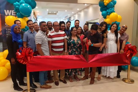 Owner of the Amazonia Mall, Ramnaresh Sarwan cutting the ribbon while the owners of the new businesses look on