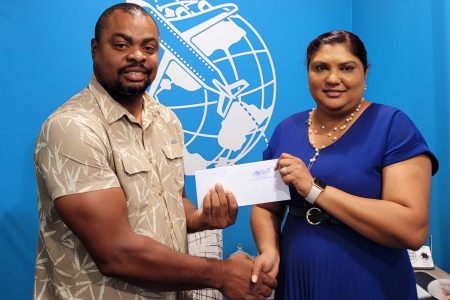 Managing Director of Delight Travel Service, Adriana Singh-Onoja (right) presents the sponsorship cheque to Edison Jefford for the Golden Mile.