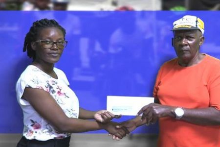  Flying Ace Cycling Club’s Randolph Roberts (right) receives the sponsorship cheque from representative of the sponsors, Malandra Simon.