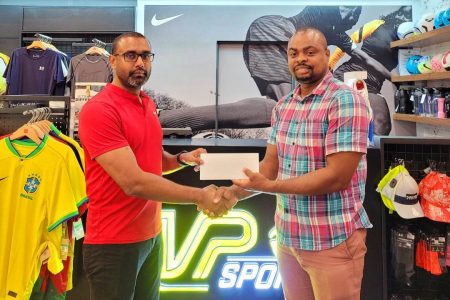 Managing Director of MVP Sports, Ian Ramdeo (left) makes his contribution to the resuscitation of the Golden Mile to Edison Jefford in the Giftland Mall Store. 