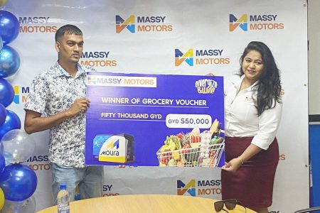 Avinash Singh receiving his $50,000 grocery voucher from Massy Motors