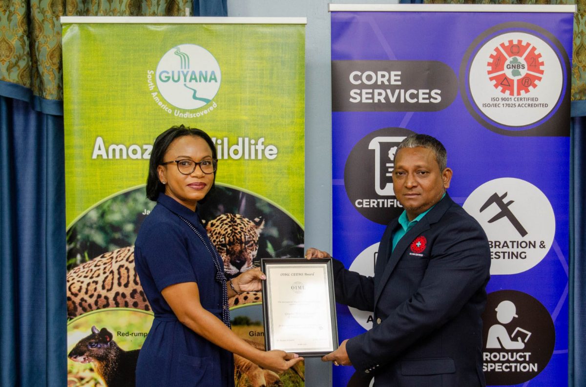 GNBS Legal Metrology Department, Shailendra Rai (right) receives the CEEMS Award from Minister of Tourism Industry and Commerce Oneidge Walrond (left).