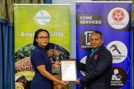 GNBS Legal Metrology Department, Shailendra Rai (right) receives the CEEMS Award from Minister of Tourism Industry and Commerce Oneidge Walrond (left).