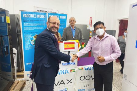 Chief Medical Officer, Dr Narine Singh (right) receiving the donation of vaccines from Spain’s non-resident Ambassador, Fernando Nogales
