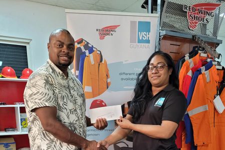 Garment Customisation Lead, Steffanie DeAbreu (right) presenting the sponsorship to Edison Jefford yesterday at the entity’s Carmichael Street Office.