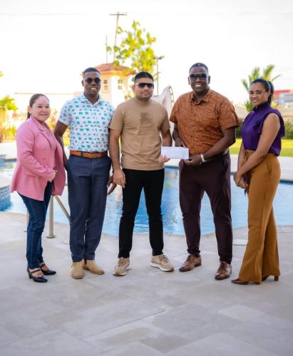 Azruddin Mohammed (center) hands over Team Mohamed’s contribution to Regatta Committee Chairman, Mr. Kenneth Williams in the presence of others