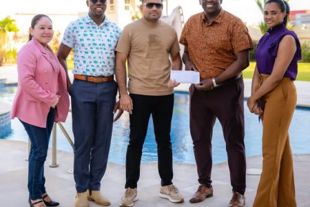 Azruddin Mohammed (center) hands over Team Mohamed’s contribution to Regatta Committee Chairman, Mr. Kenneth Williams in the presence of others