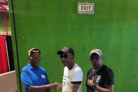 President of the Flying Ace Cycle Club Randolph Roberts, left, receives the equipment from Mark Coleman. At right is another overseas-based Guyanese, former national footballer Vibert `Cardo’ Williams.