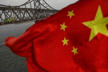 A Chinese flag is seen in front of the Friendship bridge over the Yalu River connecting the North Korean town of Sinuiju and Dandong in China's Liaoning Province, April 1, 2017.  REUTERS/Damir Sagolj