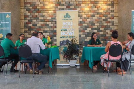 Representatives of Demerara Bank interacting with interested persons on the fund at the launch yesterday. 