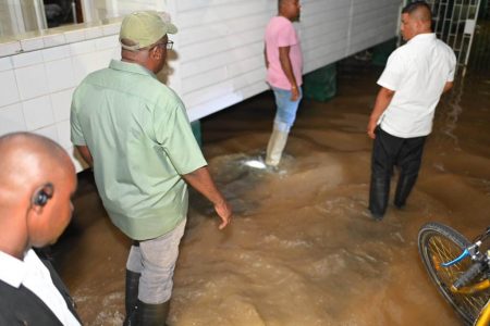 Prime Minister Mark Phillips (second from left) inspecting the flooding last night (Ministry of Public Works photo)
