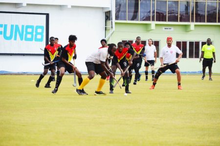 Randy Hope being challenged by several Under-21 players during a specially arranged match yesterday at the Providence National Stadium.