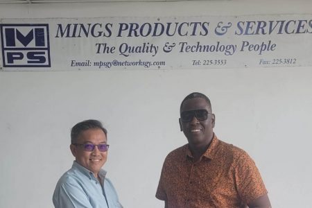 Mings Products and Services Representative, Mr. John Chin hands over cheque to Kenneth Williams.