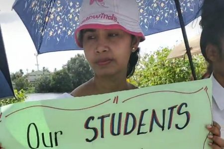 A parent demonstrating with a placard 