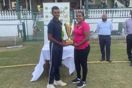 The GCB Select XI captain Dave Mohabir receives the championship trophy from Kavita Yadram. (Photo courtesy GCB)
