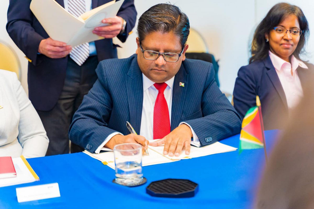Senior Minister in the Office of the President with Responsibility for Finance, Dr. Ashni Singh signing one of the agreements