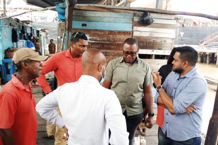 Minister of Local Government, Nigel Dharamlall (right) during a visit to the Stabroek Market yesterday

