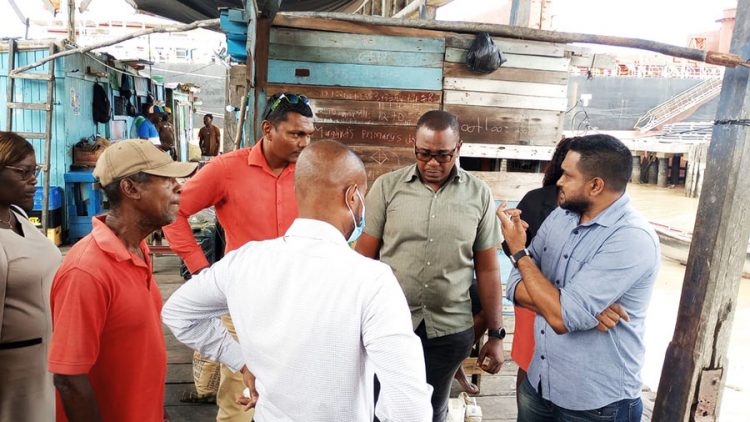 Minister of Local Government, Nigel Dharamlall (right) during a visit to the Stabroek Market yesterday
