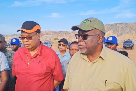 Prime Minister Mark Phillips (right) and Minster of Public Works Juan Edghill at the Bosai mining pit engaging relatives of Neptrid Hercules. 