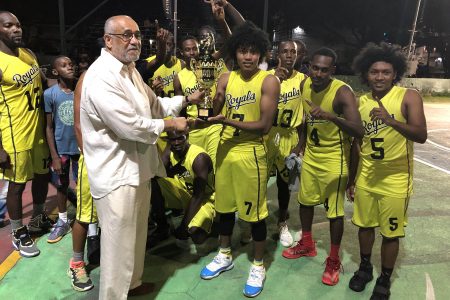 Chief Executive Officer of Leh We Ride Roy Spooner presenting the winner’s trophy to the captain of Victory Valley Royals Yannick Tappin.