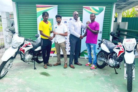 Kelsey Benjamin (left) and Abumchi Benjamin (right) receiving the keys to their Honda XR 150L motorcycles from representatives from the GFF and Marics and Company Limited
