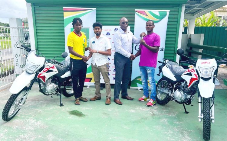 Kelsey Benjamin (left) and Abumchi Benjamin (right) receiving the keys to their Honda XR 150L motorcycles from representatives from the GFF and Marics and Company Limited
