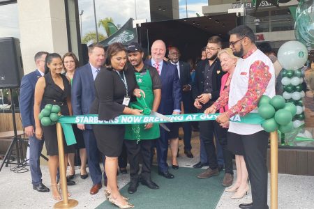 President Irfaan Ali (right), Marketing Manager of the Amazonia Mall, Cindy Ramnarine and other officials at the cutting of the Starbucks Café opening ribbon.