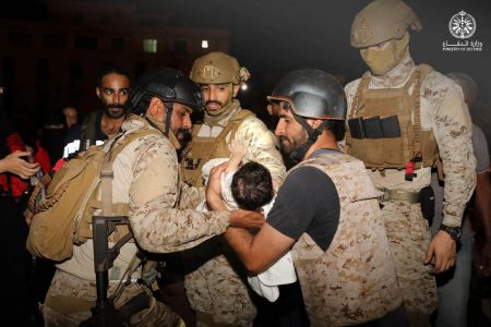 Saudi Royal Navy officers assist a child onboard their navy ship as they evacuate Saudis and other nationals through Saudi Navy Ship from Sudan to escape the conflicts, Port Sudan, April 22, 2023. (Reuters photo)