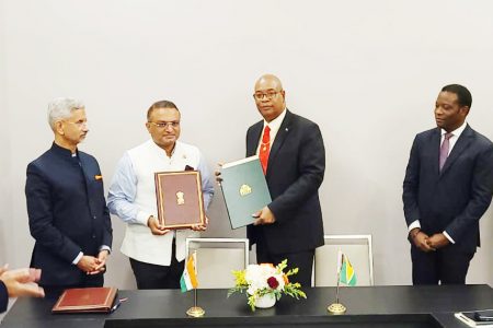 Minister of Public Works Juan Edghill (second from right) and High Commissioner of India to Guyana Dr. K. J. Srinivasa (third from right) with the agreement. At right is Guyana’s Minister of Foreign Affairs Hugh Todd. Indian Minister of External Affairs Dr. Subrahmanyam Jaishankar is at left. (GCAA photo)
