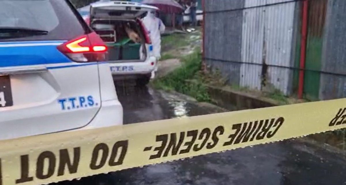 A crime scene investigator at the scene of the triple murder in Charlo Village in Penal, on Tuesday 25 April 2023. [Image by Rishi Ragoonath]


