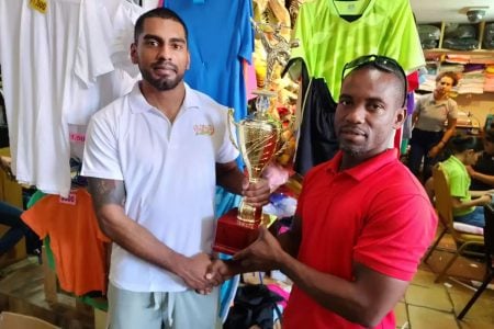 Roland Eudoxie (right) receives the  trophies from Jonathan Sunich.
