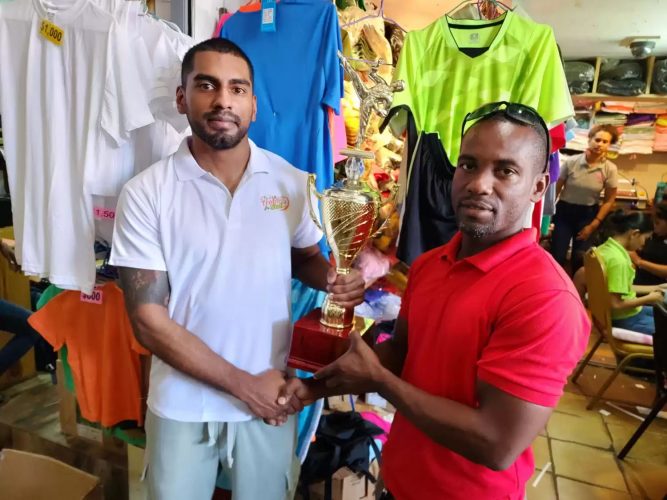 Roland Eudoxie (right) receives the  trophies from Jonathan Sunich.
