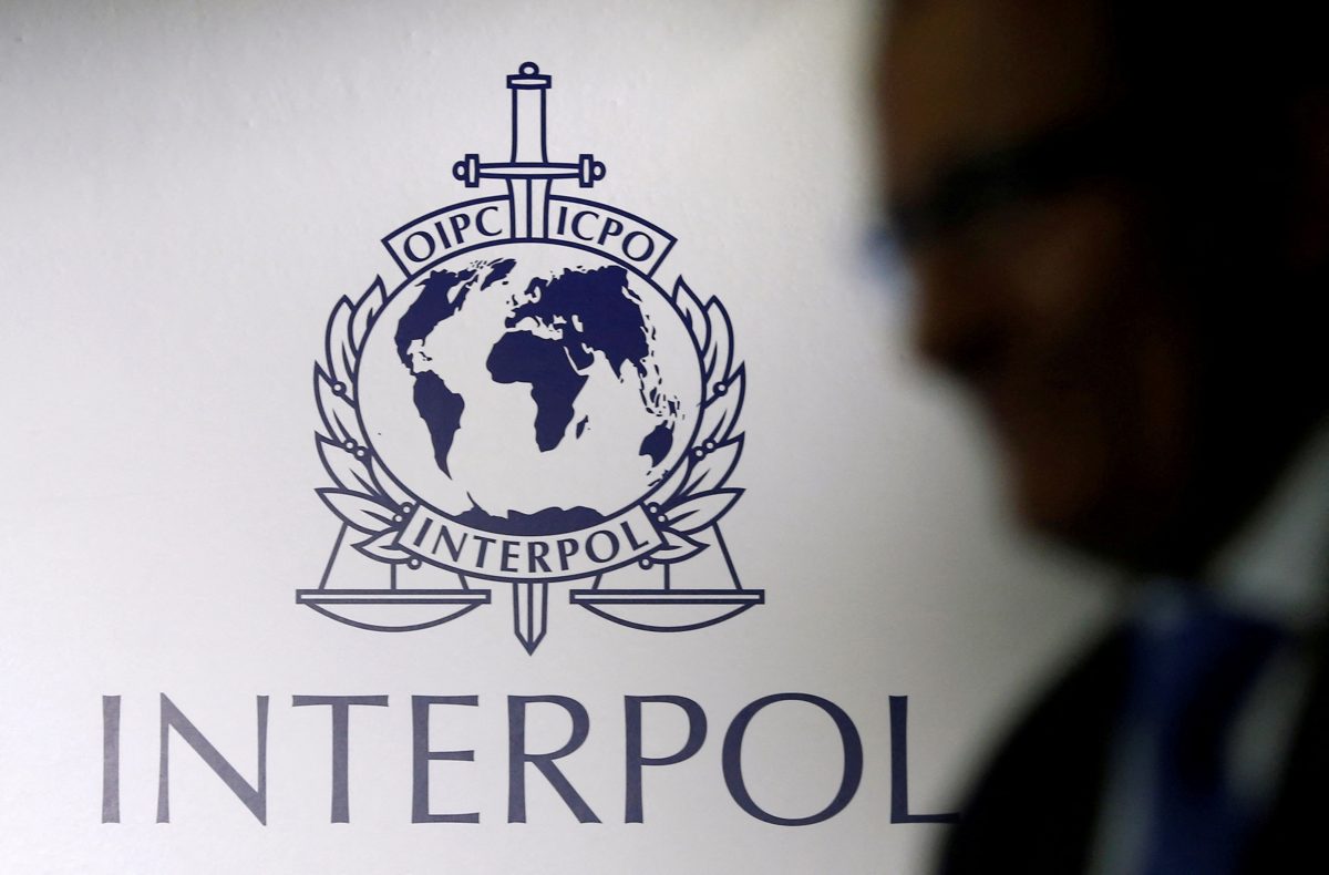 FILE PHOTO: A man passes an Interpol logo during the handing over ceremony of the new premises for Interpol’s Global Complex for Innovation, a research and development facility, in Singapore September 30, 2014. REUTERS/Edgar Su//File Photo