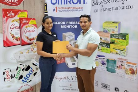 Kares CrossFit Caribbean Championship organizer, Jamie McDonald receiving sponsorship from the CEO of DeSincoTrading Limited, Alicia DeAbreu